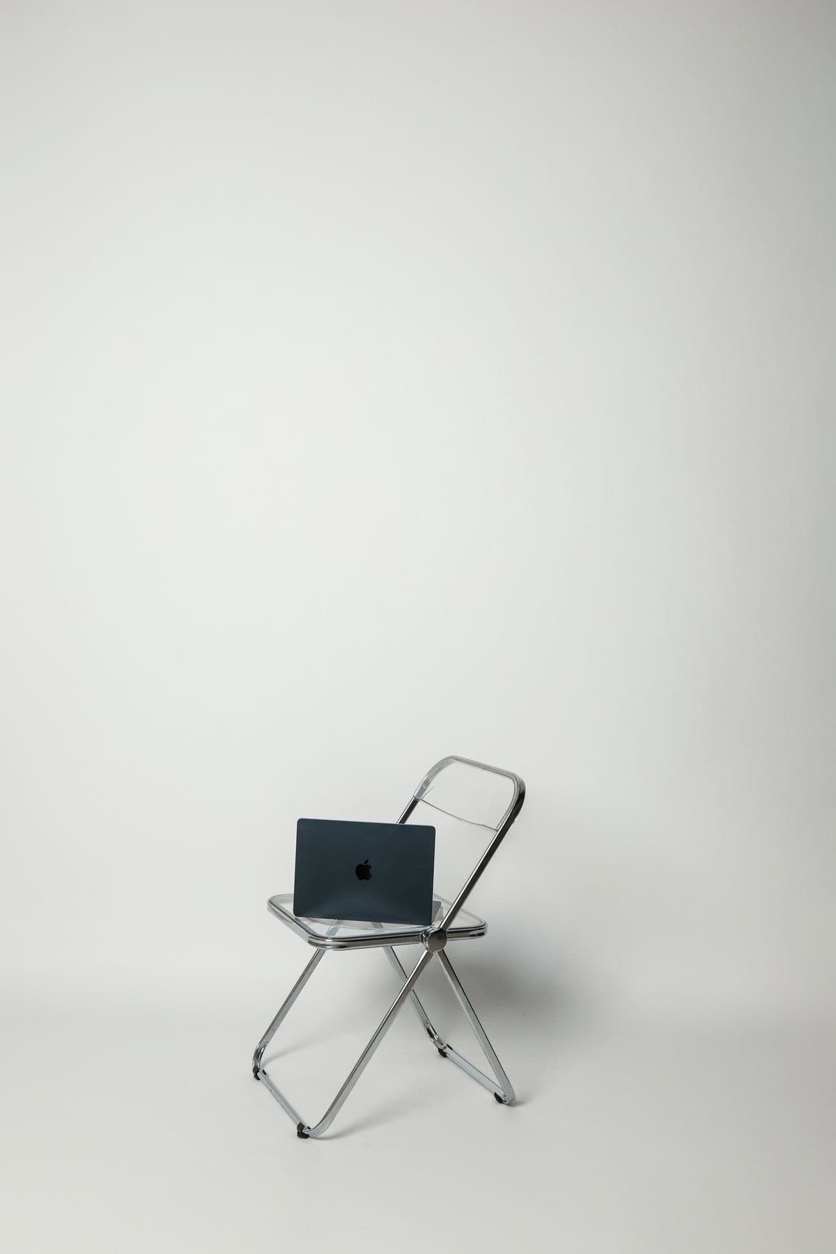 Portátil sobre una silla en un espacio minimalista.